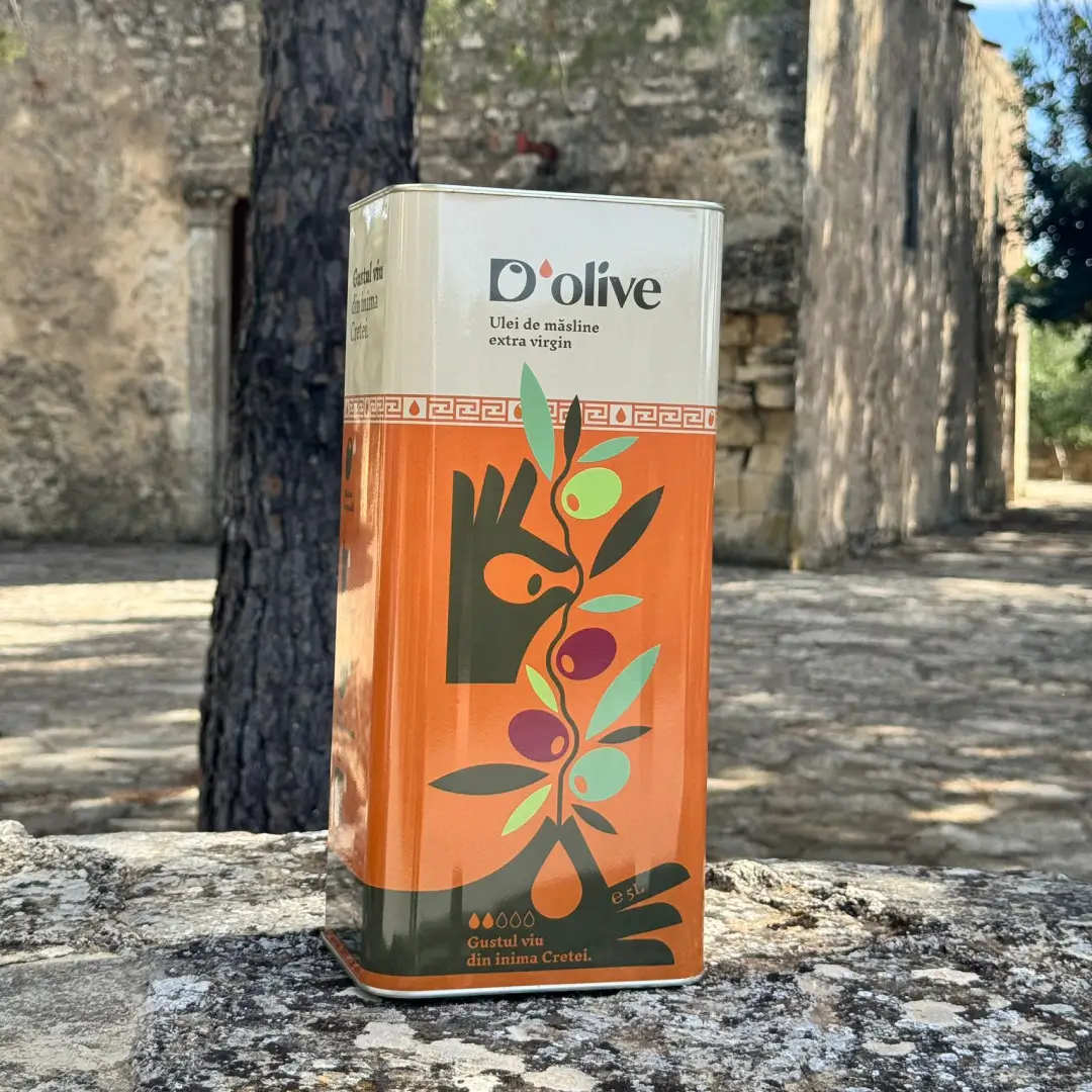 Ulei de măsline extravirgin D’Olive Gustul Prietenos, în recipient de 5 litri așezat pe un zid de piatră, într-un decor mediteraneean din Creta.